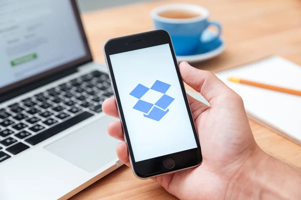 Man holding iphone 6 showing Dropbox app