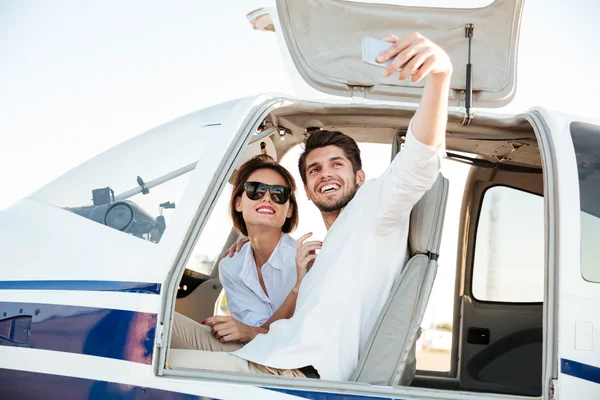 Happy smiling couple making selfie inside plane cabin