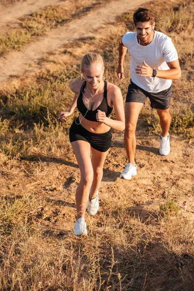 Athletic female runner and male fitness model running together