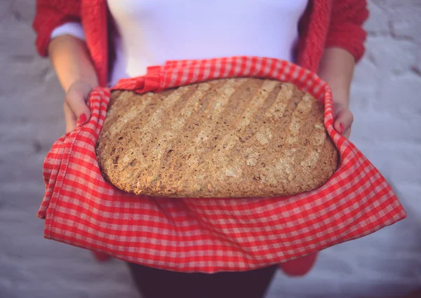 Woman baker holding freshly baked bread - Home meade bun of brea