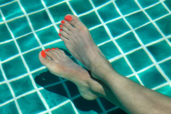 Female Feet with Red Polish on Finger Nails Soaked in a Water Pool at Summer