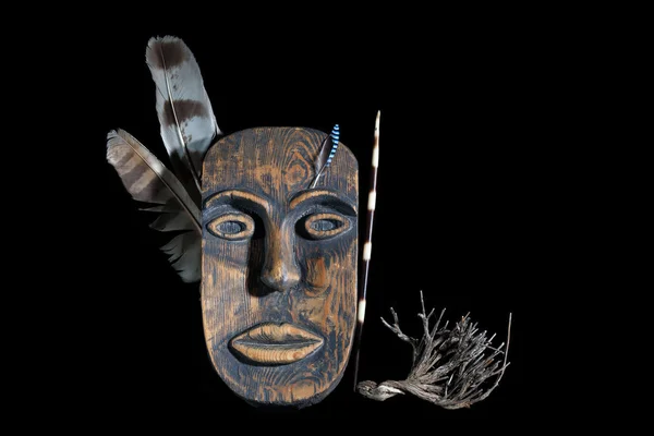 Decorative mask with feather of warrior on a black background handmade. Mask of the American Indian