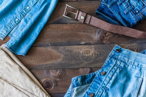 Jeans, denim shirt, of casual, leather belt, jeans jacket on the wooden background wenge
