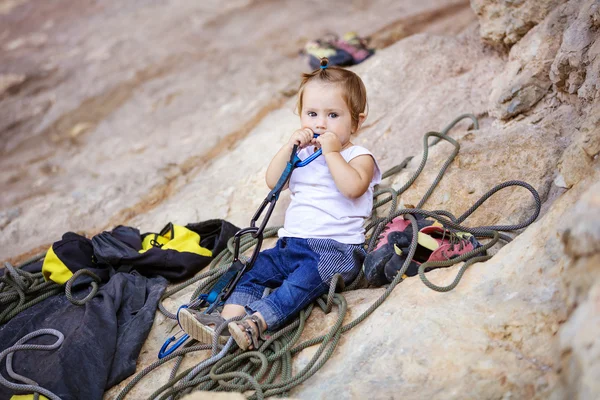 Little girl playing with climbing gear