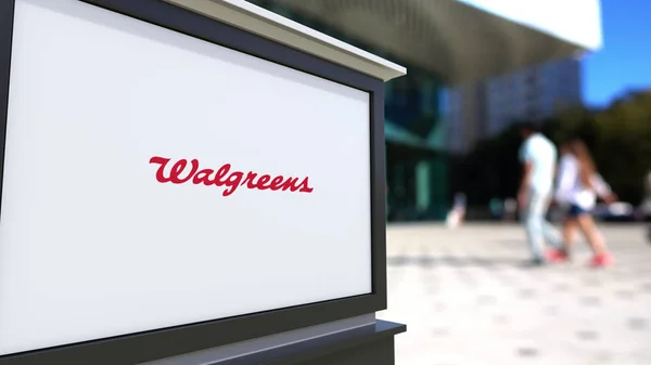 Street signage board with Walgreens logo. Blurred office center and walking people background. Editorial 3D rendering