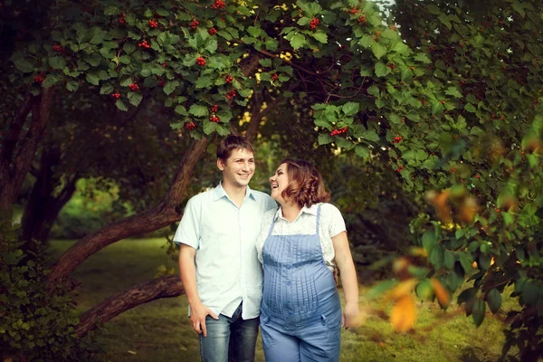 Happy couple expecting a baby walks in summer in a beautiful Par