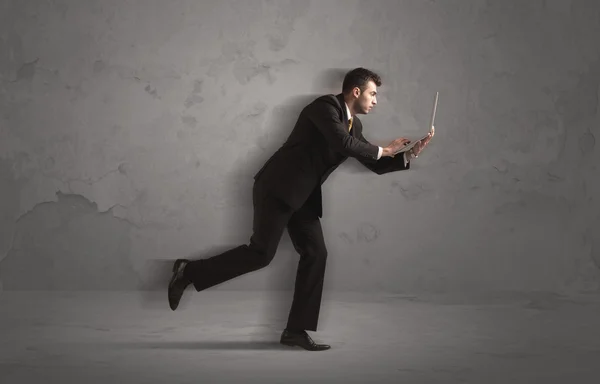 Running businessman with device in hand