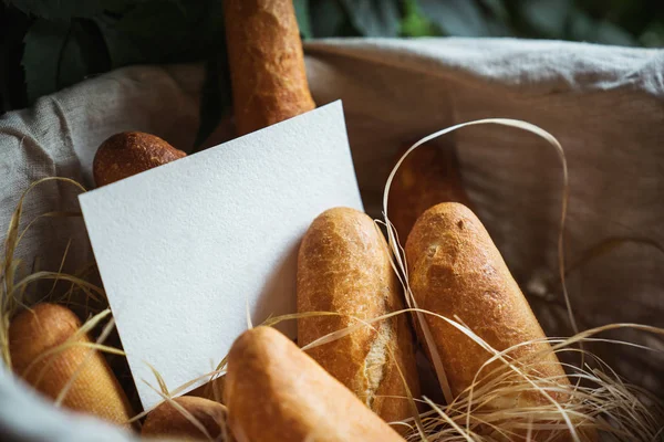 Basket filled with bread. Blank sheet of paper for the label.