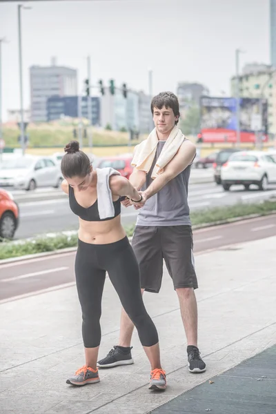 Friends helping each other doing stretching