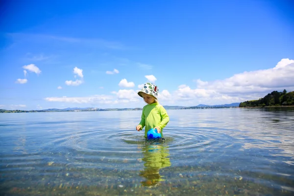 Little girl in green shirt playing in the water. Whangarei beach