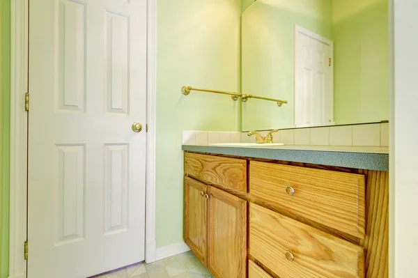 Green bathroom interior, close up of vanity cabinet