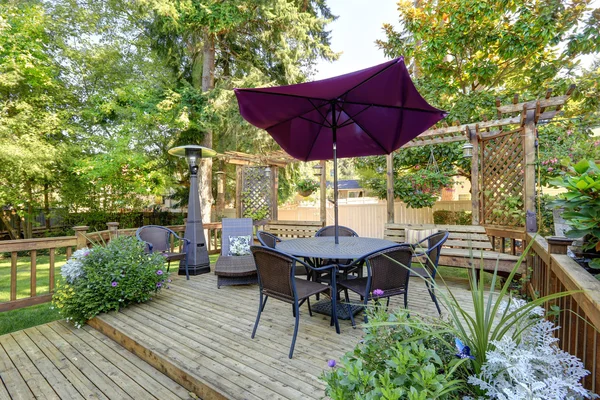 Backyard patio area with outdoor wicker furniture