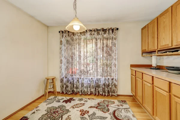 Empty dining room interior with window curtain, colorful rug