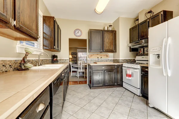 Kitchen room - dark brown cabinets and white appliances