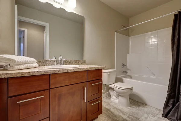 Clean and warm bathroom interior with tile floor and beige walls