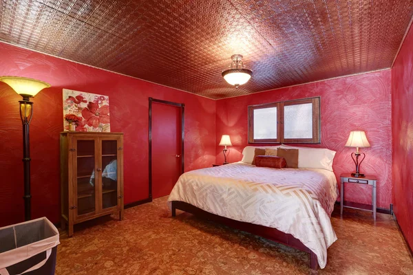 Red bedroom with queen size bed and linoleum floor.