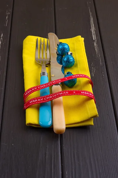 Christmas New Year background. set fork, knife, spoon on yellow napkin with decoration Holiday gold ribbon, blue ball