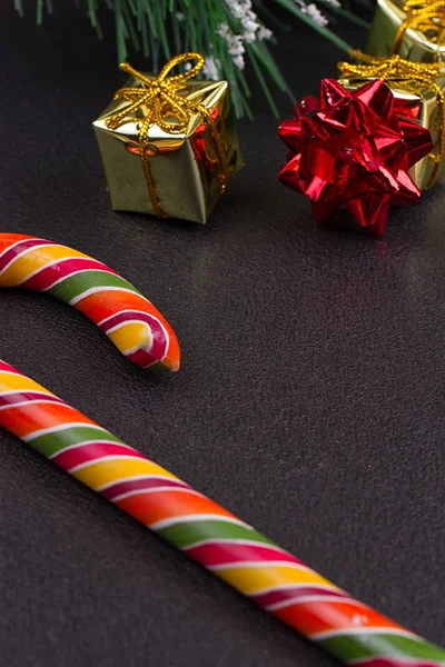 Christmas gift, tree branch and decorations on dark slate background