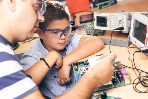 Little boy and teacher in class with electronic project