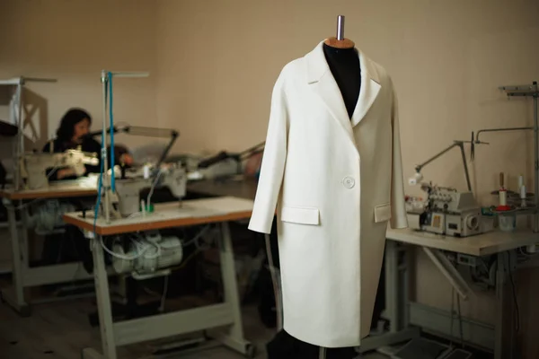 White coat on a mannequin in a sewing workshop
