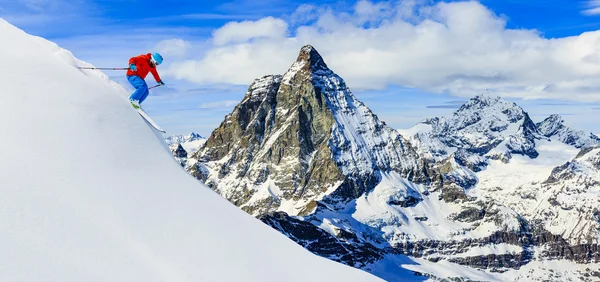 Skier skiing downhill in high mountains in fresh powder snow. Sn