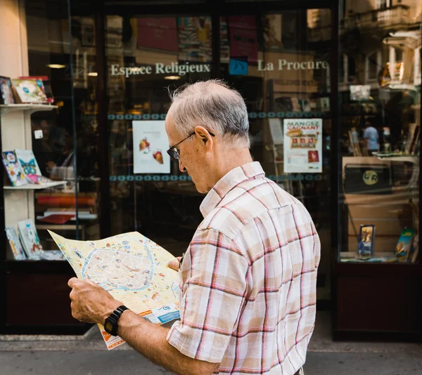 Senior man reading map in new city