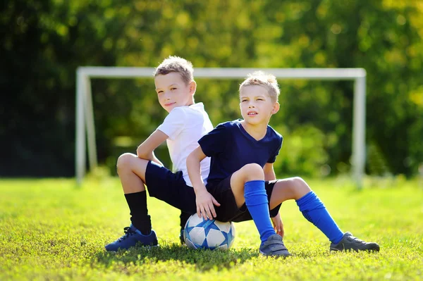Two little brothers having fun playing a soccer game