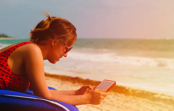 Woman with touch pad on tropical beach