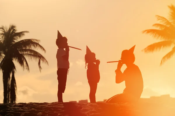 Beach family party - father and kids play at sunset