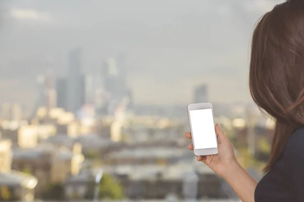 Woman holding white cellular phone