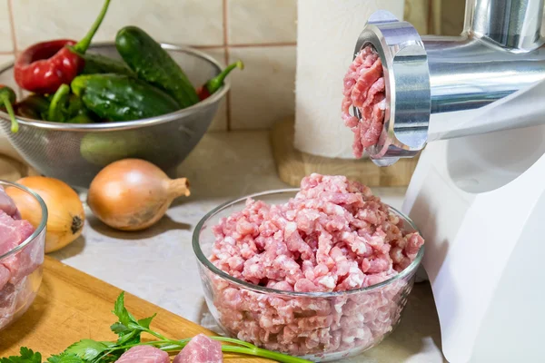 Home electric meat-grinder is making pork stuffing