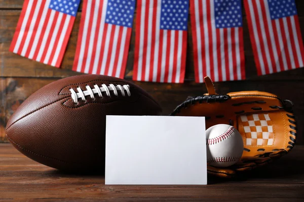 American flags with sport items on wooden background