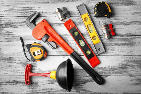 Plumber tools on a wooden structure background