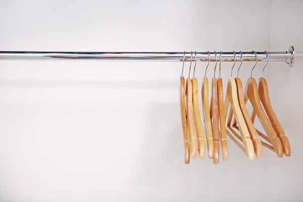 Wooden coat hangers on clothes rail
