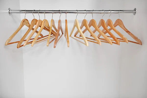 Wooden coat hangers on clothes rail