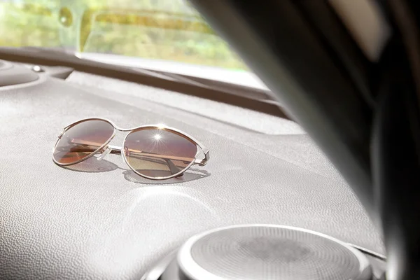 Sunglasses on car panel