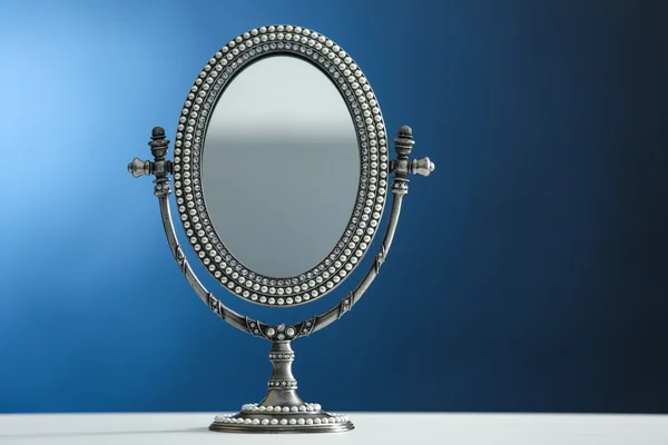 Female mirror on color background