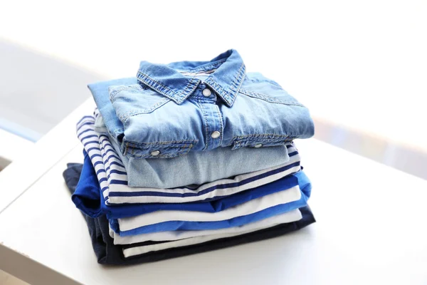 Pile of clothes on white table, closeup