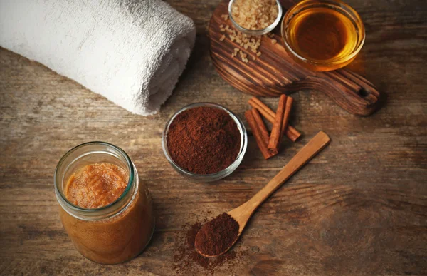 Body scrub and coffee on wooden background