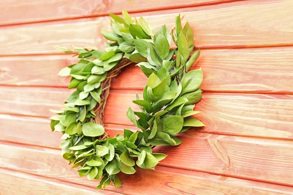 Green wreath hanging on wooden wall