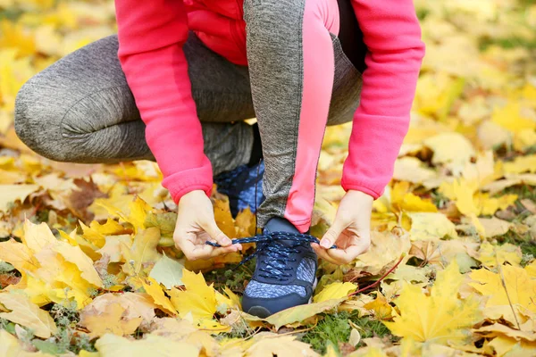 Young woman tying sport shoes