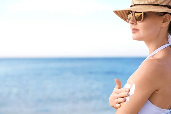 Woman applying sun protective lotion