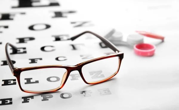Glasses lying on eye test chart