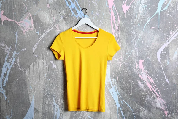 Yellow t-shirt against grunge wall