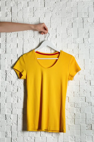 Yellow t-shirt against brickwall