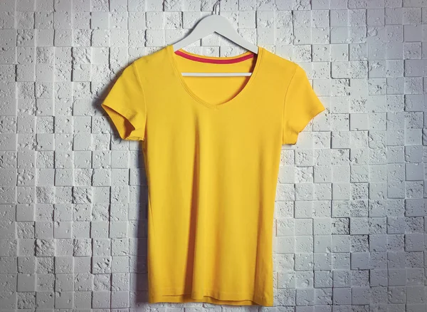 Yellow t-shirt against brickwall