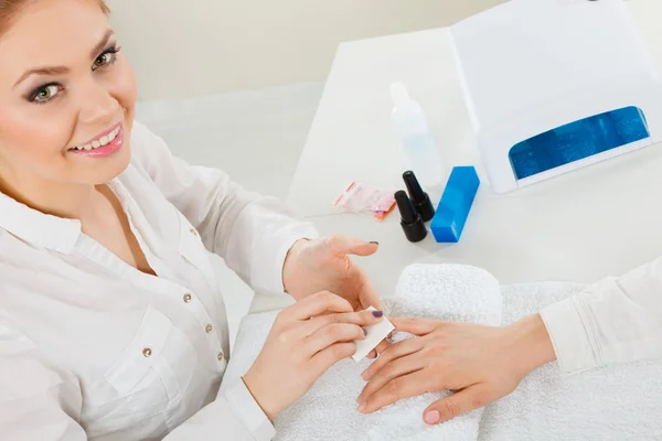 Female beautician making nails.