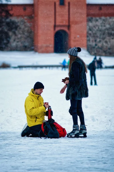 Young girl and fellow at winter rink in Trakai Lithuania