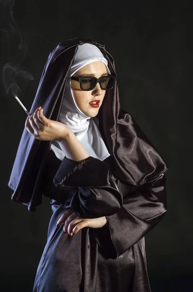 Portrait of a smoking young nun