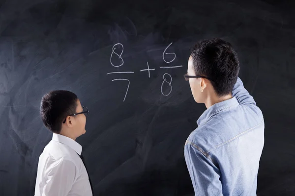 Schoolboy learns math lesson with teacher